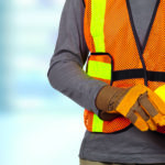 Worker with helmet in orange security vest.